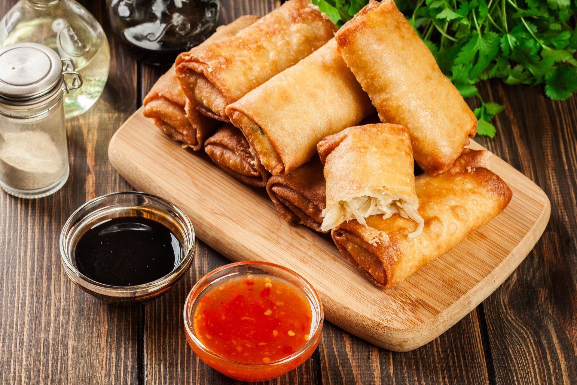 Spring rolls with chicken and vegetables on chopping board. Asian cuisine.